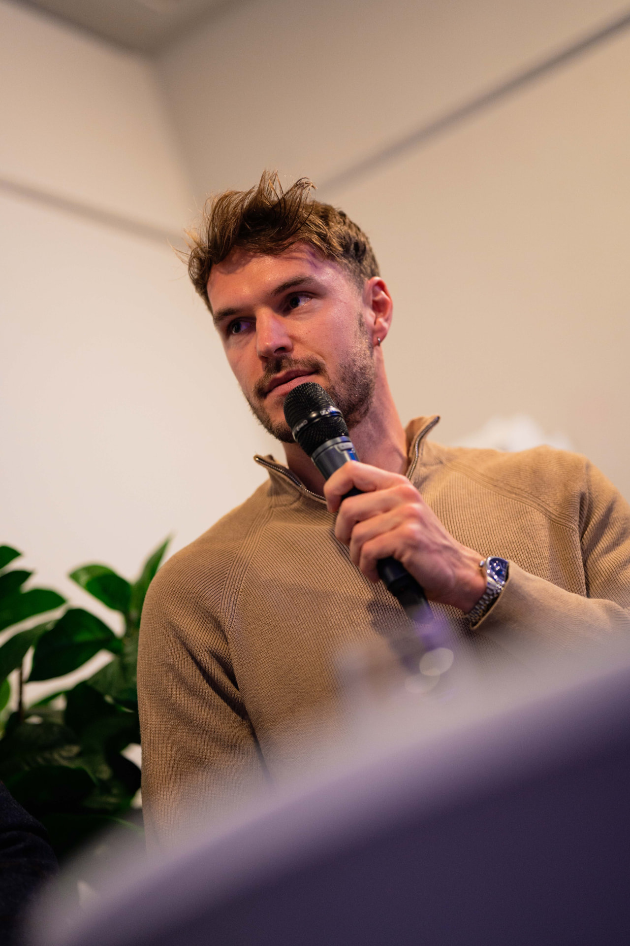 Lennart Mertens speaking into a microphone at an event